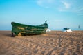 Green fishing boat on the beach and blue sky