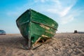 Green fishing boat on the beach and blue sky