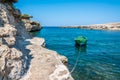 A green fishing boat bobs in a sheltered inlet near Polignano a Mare, Puglia, Italy