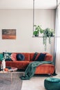 Green flowers on stylish swing in classy living room interior with corner sofa with pillows Royalty Free Stock Photo