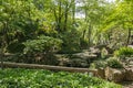 Green foliage and people on bridge at Humble Administrators Garden, Suzhou, China