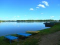 Lake shore summer landscape and bench blue sky background Royalty Free Stock Photo