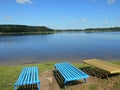 Lake shore summer landscape and bench blue sky background Royalty Free Stock Photo