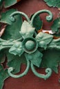 Green forged flower close-up. Fragment of decor of old doors as a background Royalty Free Stock Photo