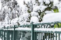 Green forged metal fence covered with snow. Winter landscape Royalty Free Stock Photo