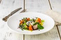 A green French bistro style salad with poached egg and chives on a white plate and table setting Royalty Free Stock Photo