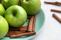 Green fresh apples and fragrant cinnamon sticks close up