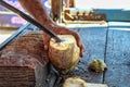 Green fresh coconut peeling and shelling with heavy chop knife for juice.the man using heavy knife to chop green fresh coconut