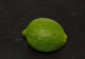 Green fresh exotic citrus fruit lime on a black background Royalty Free Stock Photo