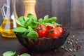 Green fresh leaves of organic basil and small ripe tomatoes, oil and pepper Royalty Free Stock Photo