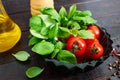 Green fresh leaves of organic basil and small ripe tomatoes, oil and pepper Royalty Free Stock Photo