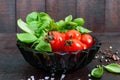 Green fresh leaves of organic basil and small ripe tomatoes and pepper on a wooden background Royalty Free Stock Photo