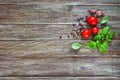 Green fresh leaves of organic basil and small ripe tomatoes salt and pepper on a wooden background Royalty Free Stock Photo