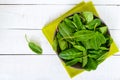 Green fresh leaves of sorrel spinach in a ceramic bowl in water drops, on a white wooden background. Royalty Free Stock Photo