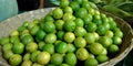 green fresh organic produce lemon kept on basket at vegetable store Royalty Free Stock Photo