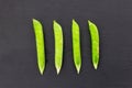 Green fresh pea pod parallel row of vegetables on a black background contrasting design set Royalty Free Stock Photo