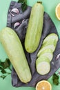 Green fresh ripe zucchini whole and cut into slices on a cloth napkin surrounded by sprigs of parsley, garlic and lemon Royalty Free Stock Photo