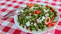 Green fresh salad with rucola, lettuce, cherry tomatoes and flakes of parmesan cheese