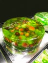 Green fresh tropical fruit pie jelly with varieties of fruits selection, apple, grape, peach, strawberry and dragon fruit