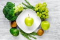 green fresh vegetables, fruits and apple on plate for healthy salad gray background top view Royalty Free Stock Photo