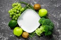 Green fresh vegetables and fruits for healthy salad on dark table background top view Royalty Free Stock Photo