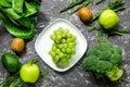 Green fresh vegetables and fruits for healthy salad on dark table background top view Royalty Free Stock Photo