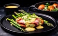 green fried asparagus, bacon, and fried potatoes with mustard sauce on a white plate.