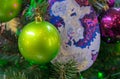 Green frosted Christmas ball on a Christmas tree close-up.