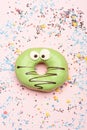 Green funny surprised donut on pink background