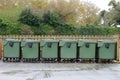 Green garbage containers arranged in a row on the street Royalty Free Stock Photo