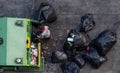 Green garbage truck And the employees are collecting a lot of black garbage bags that are tied up On the sidewalk To discard Viewe