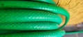 green garden hose rolled up in yard on a sunny day Royalty Free Stock Photo