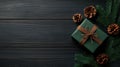 Green gift box with brown ribbon and pine cones on wooden table Royalty Free Stock Photo