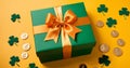 Green gift box with golden bow and clover leaves on yellow background Royalty Free Stock Photo