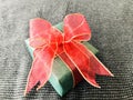 Green gift with red organza ribbon on Houndstooth background.