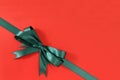 Green gift ribbon bow corner diagonal red paper background Royalty Free Stock Photo