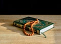 A green and gilded book of Quran and a rosary Royalty Free Stock Photo