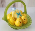 Green glass Easter basket, plastic chick eggs, fuzzy chick with bunny ears and a bow