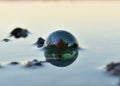 A green glass bead in the water reflecting the light Royalty Free Stock Photo