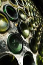 Green glass bottle bottoms immured in textured concrete wall background in perspective Royalty Free Stock Photo