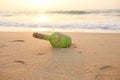 Green glass bottle with a message inside on the seashore on the beach. Magic and fairy tale. Design with copy space Royalty Free Stock Photo