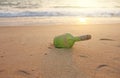 Green glass bottle with a message inside on the seashore on the beach. Magic and fairy tale. Design with copy space Royalty Free Stock Photo