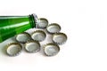 Green glass bottle of mineral water and metal soda bottle with caps, soda caps, close-up on white background Royalty Free Stock Photo