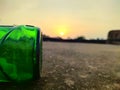 Green glass bottles of beer at sunset sky. Empty beer bottle. Royalty Free Stock Photo