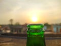 Green glass bottles of beer at sunset sky. Empty beer bottle. Royalty Free Stock Photo