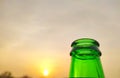 Green glass bottles of beer at sunset sky. Empty beer bottle. Royalty Free Stock Photo