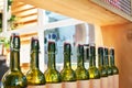 Green glass bottles of wine in line on wooden shelf, bar interior design, wine tasting concept, nightlife style, winery production