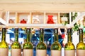 Green glass bottles of wine in line on wooden shelf, bar interior design, wine tasting concept, nightlife style, winery production