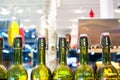 Green glass bottles of wine in line on wooden shelf, bar interior design, wine tasting concept, nightlife style, winery production Royalty Free Stock Photo