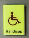 Green glass handicap sign on grey wall Royalty Free Stock Photo